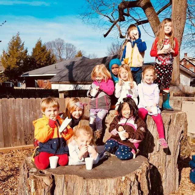 Children having a snack on logs