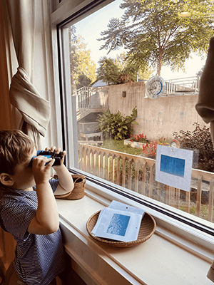 Child looking out the window with binoculars